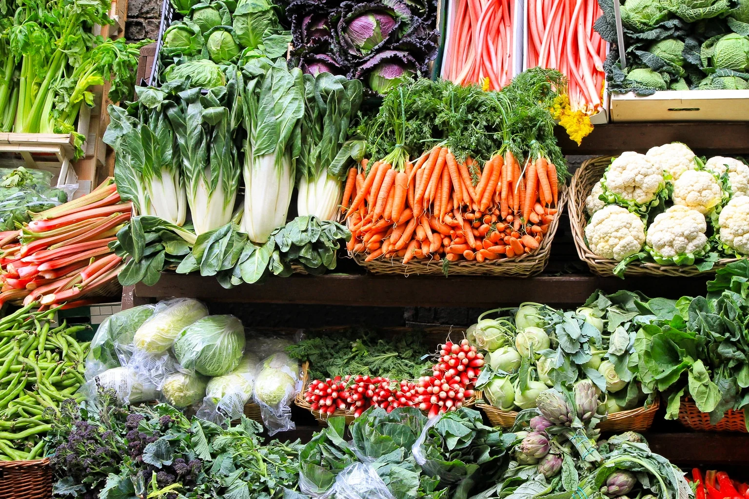 An image of a well stocked farmers market stall with fresh vegetables and lots of high value crops. 