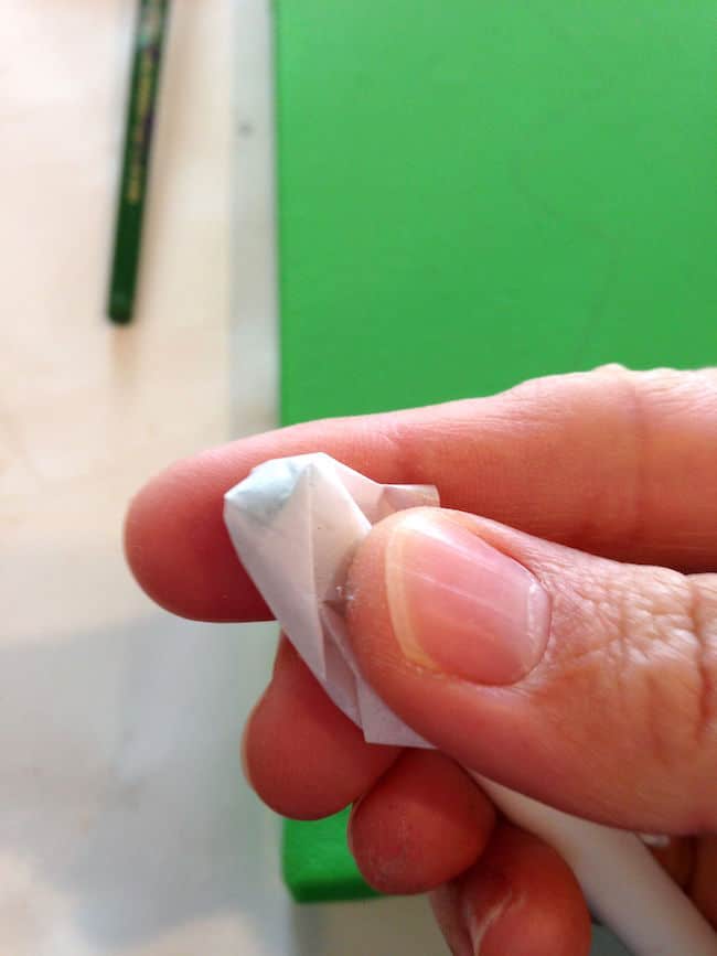 Wrapping tissue paper around the end of a pencil