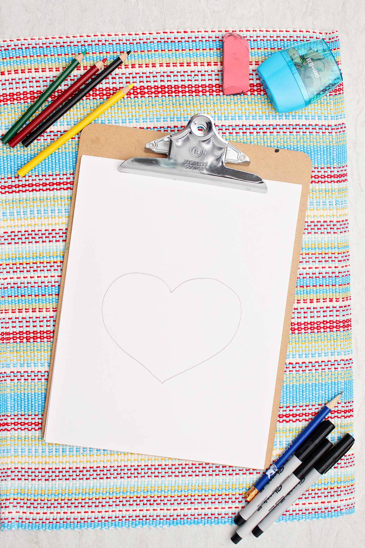 A simple heart drawn on a piece of paper in pencil to start off the face on their Grinch sketch.