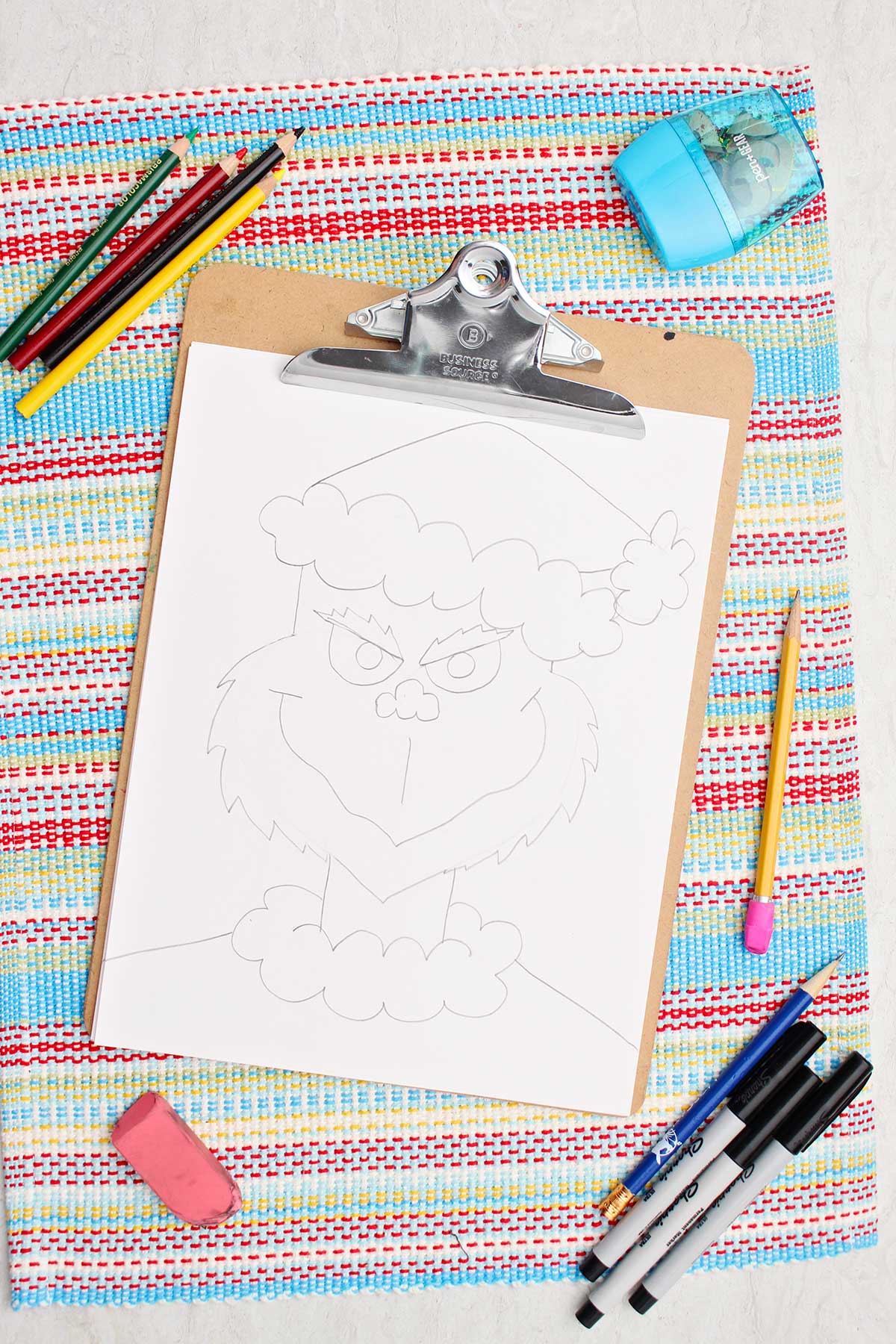 A pencil sketch of The Grinch wearing a Santa outfit.