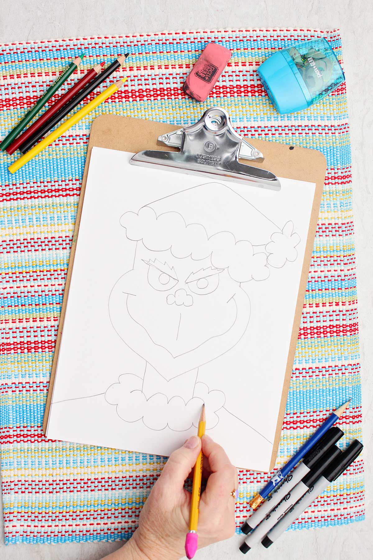 Person adding trim details to the Grinch's Santa coat.