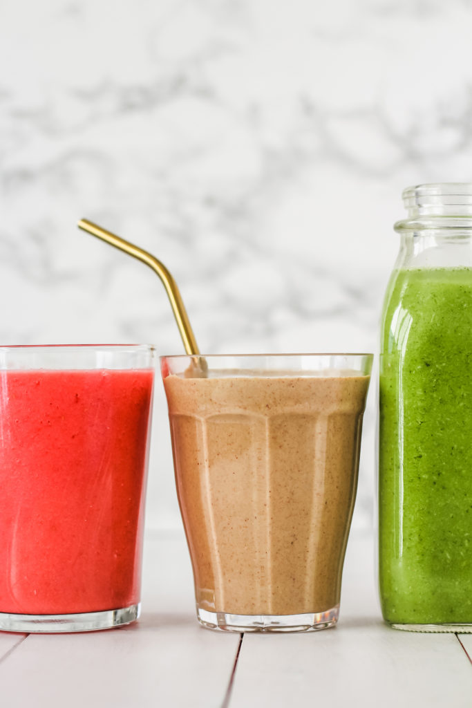 Glasses of juice with a stainless steel straw.