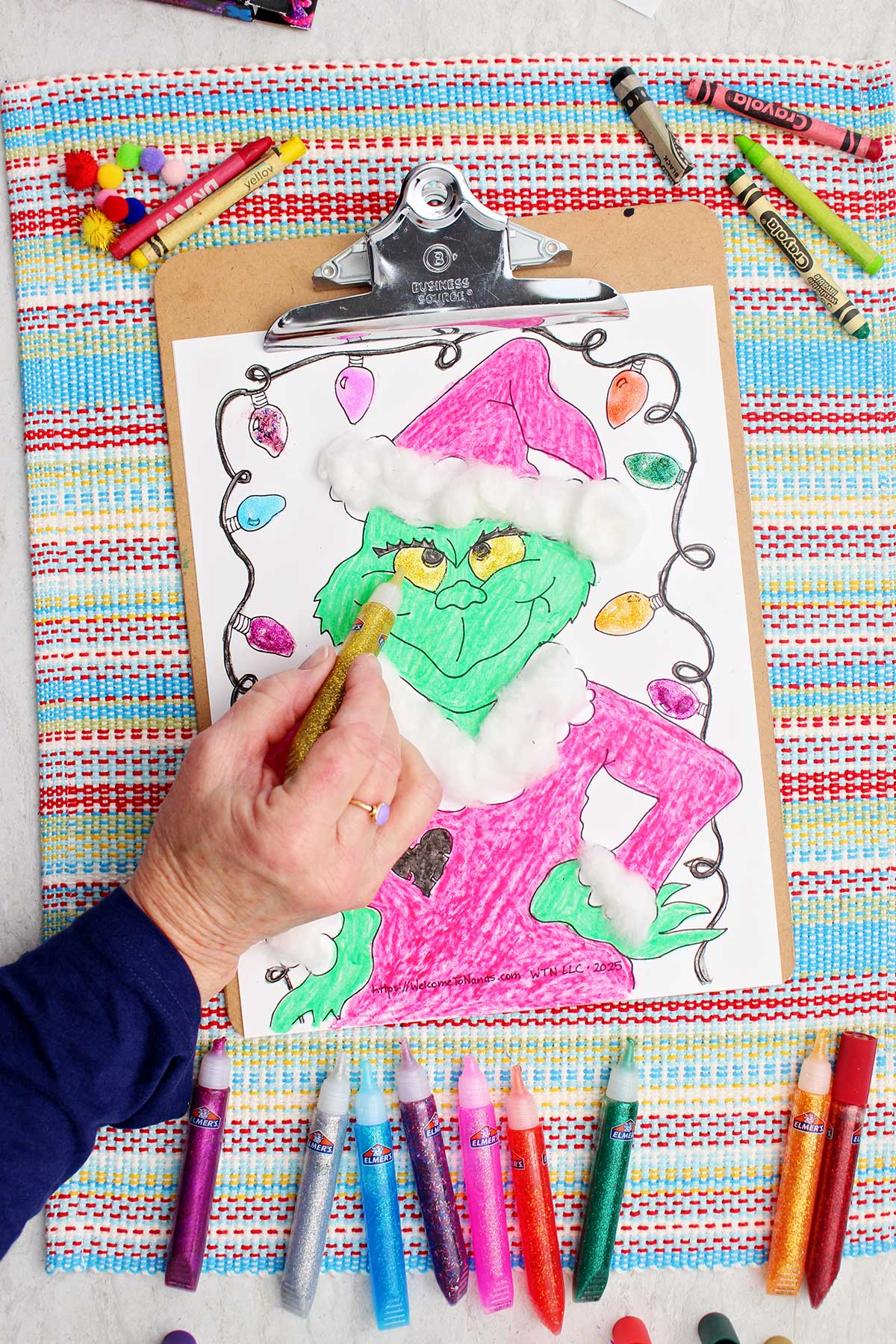 Person filling in Grinch eyes with gold glitter glue.