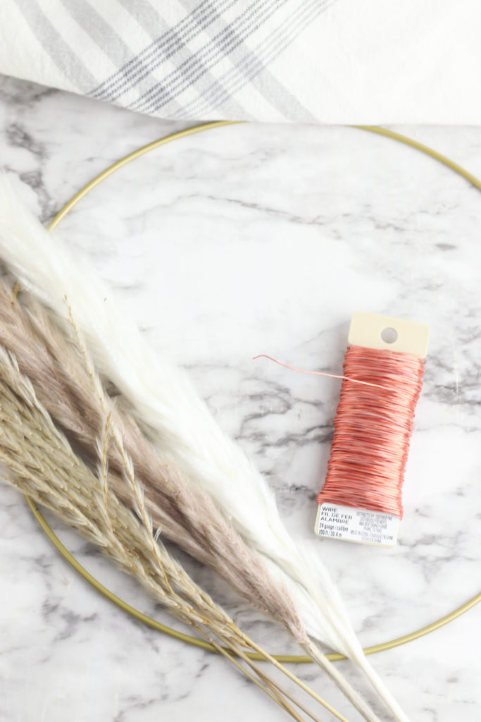 Supplies needed to make a pampas hoop wreath including a metal hoop ring, pampas grass and floral wire.