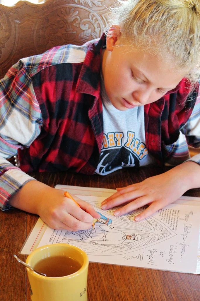 Coloring the manger scene on a Christmas coloring page.