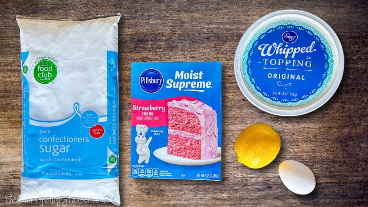 Pink lemonade crinkle cookies arranged in neat rows on a baking sheet, dusted with powdered sugar and baked until cracked on top.