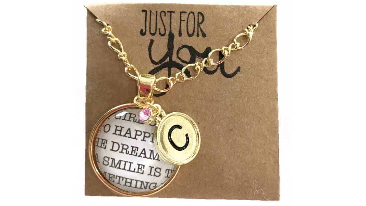 Gold chain necklace with a round monogram pendant and small charm displayed on a kraft jewelry card that reads Just for You.