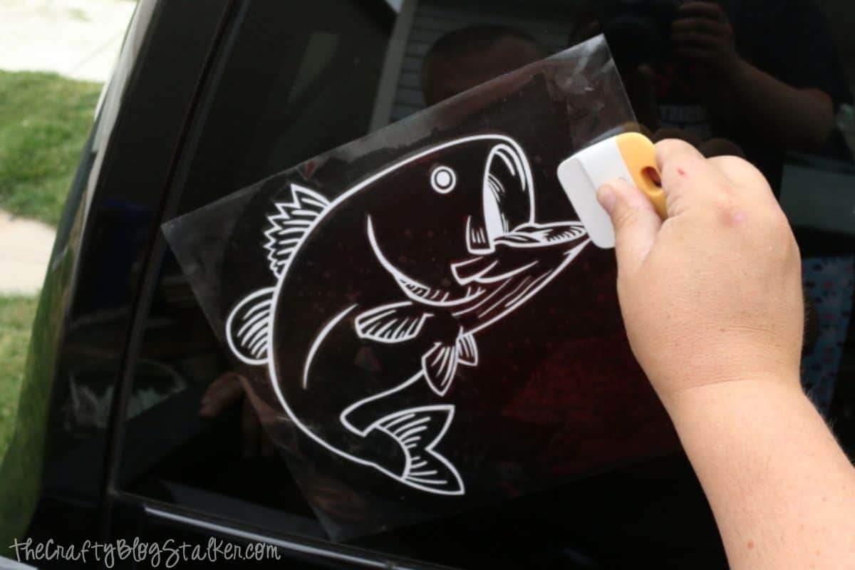 Applying a bass decal to the back window of a truck.